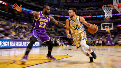 NBA常规赛湖人队对阵勇士队比赛中，詹姆斯与库里对位的精彩画面